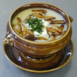 Wegetariański żurek podany z podsmażonymi grzybami