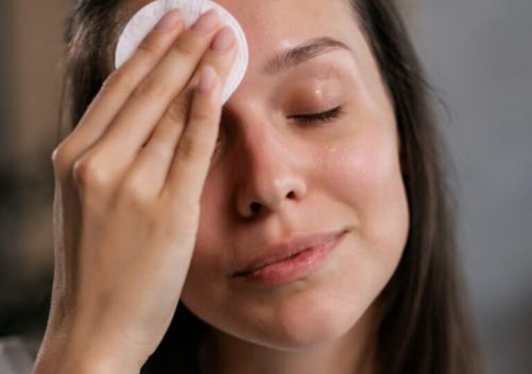 Młoda kobieta oczyszcza twarz hydrolatem różanym