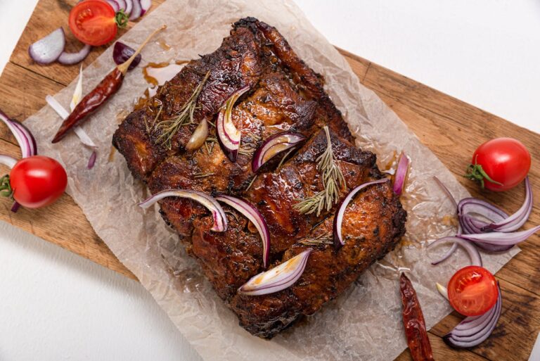 Kawałek pieczonego w domu schabu na drewnianej desce