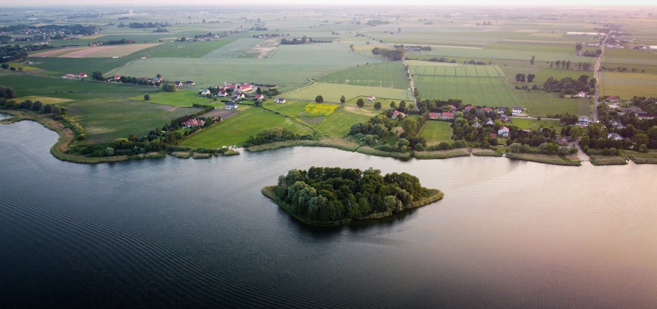 Krajobraz Mazowsza z wodą i zadrzewioną wyspą